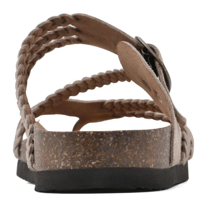 Woman wearing Kaelen braided cork sandals, walking on a paved pathway, illustrating comfort and mobility.